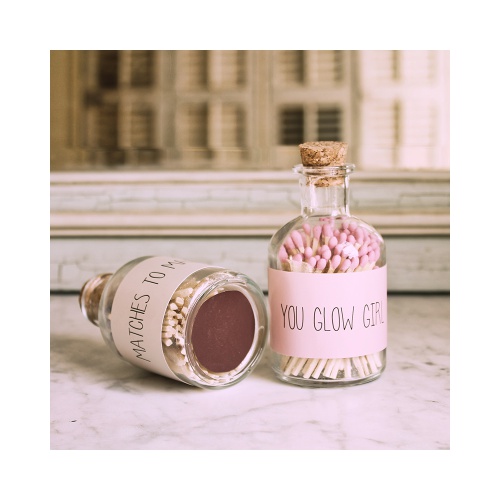 Een glazen potje met 80 roze lucifers. Met deze lucifers ben je helemaal in stijl met een matchende kaars. Het potje wordt gesierd met de tekst 'You Glow Girl'. 
Het strijkvlak zit op de onderkant van het potje om de lucifers aan te steken.